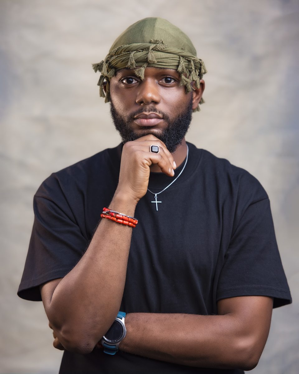 David Williams in a green headwrap, hand on chin